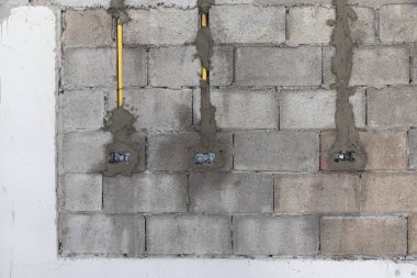 İşçi yeni mutfak duvarındaki elektrik prizleri ve duvar anahtarlarının konumu için etiket işaretliyor.