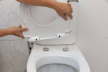 Tamirci, klozet kapağını değiştir. Tuvalet kapağı değiştirme konsepti.