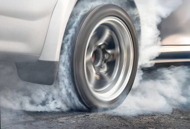 Yarış arabası başlangıç çizgisinde lastikleri yakıyor..