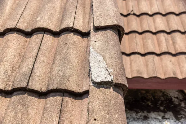 Tamire ihtiyacı olan hasarlı eski çatı kiremiti.