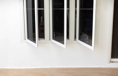Üç panel alüminyum pencere beyaz duvarda kalıyor.