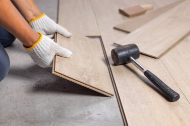Worker Installing Interlocking laminate floor, home renovation.