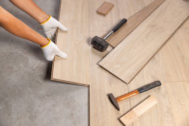 Worker Installing Interlocking laminate floor, home renovation.