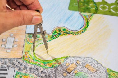 Bahçe tasarım dersleri öğrencisi el çizimiyle bahçe planını öğreniyor..