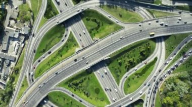 Yol ayrımında muhteşem bir dönüş açısı. Otoyol, güneşli bir günde birden fazla yol, küçük araba trafiği olan köprüler gösteriyor.