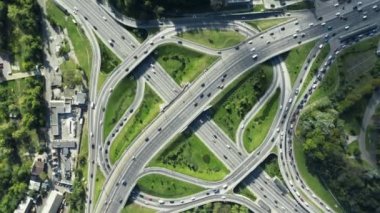 Yol ayrımında muhteşem bir dönüş açısı. Otoyol, güneşli bir günde birden fazla yol, küçük araba trafiği olan köprüler gösteriyor.