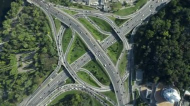 Yol ayrımında muhteşem bir dönüş açısı. Otoyol, güneşli bir günde birden fazla yol, küçük araba trafiği olan köprüler gösteriyor.