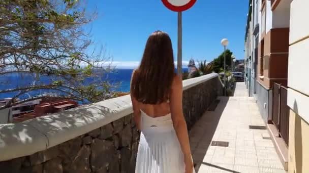 スペインのテネリフェ島の海岸線に沿ってカンデラリアの通りを歩く若い女性 — ストック動画
