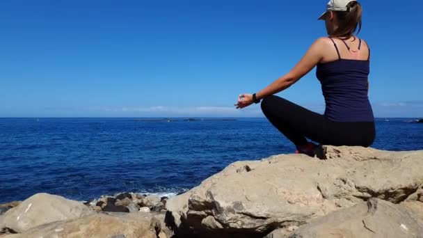 Young Relaxed Woman Meditating Sitting Boulder Ocean Coast — Wideo stockowe