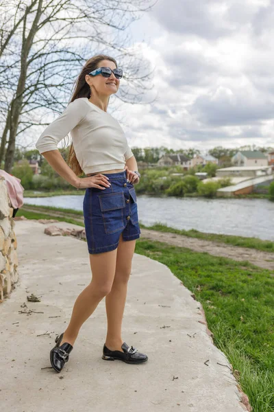 Göl Boyunca Yürüyen Kısa Kot Etekli Bluzlu Genç Bir Kadın — Stok fotoğraf