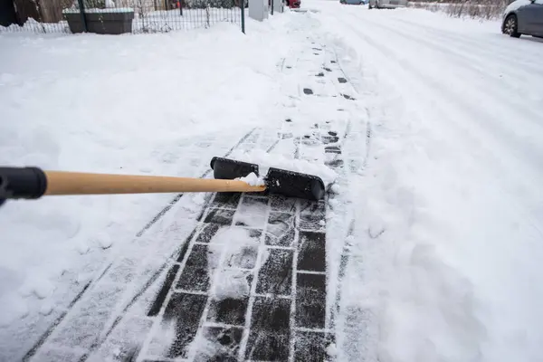 clearing snow from the sidewalk