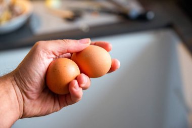 Bulanık arka planda yumurtayı tutan adam.