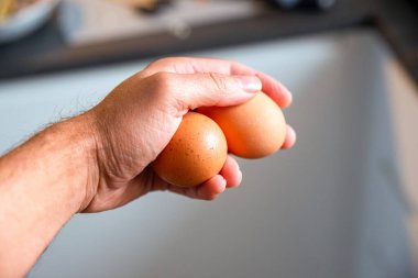 Bulanık arka planda yumurtayı tutan adam.