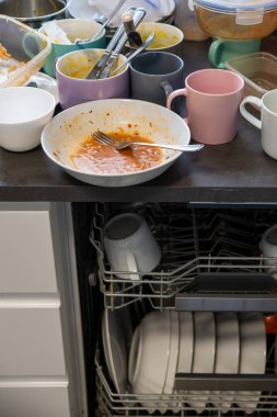 Mutfak masasındaki kirli bulaşıklar, birinin onları bulaşık makinesine koymasını bekliyor.