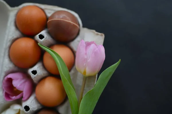 美しく装飾されたイースターエッグ 花とチョコレートの卵の箱に 黒の背景 — ストック写真