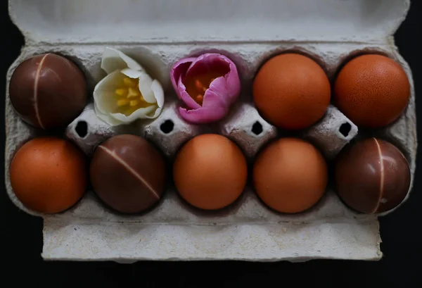 Prachtig Versierde Paaseieren Een Doos Bloemen Chocolade Eieren Zwarte Achtergrond — Stockfoto