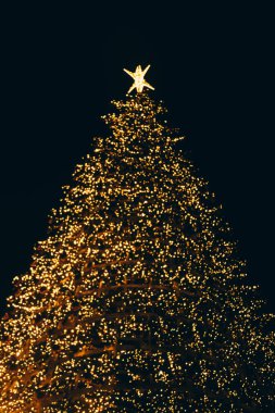 Lizbon şehrinde yılbaşı ağacı. Portekiz 'de Noel ışıkları. turuncu ve sarı parlak çelenkler, bulanık sırtüstü