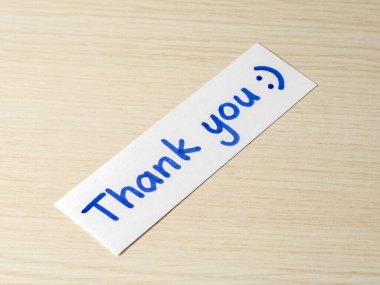 Tahta bir masanın üzerine mavi kalemle yazılmış 