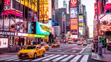 View of New York city in the USA at Times Square showcasing its lights, stores, traffic, and lots of tourists and locals passing by.