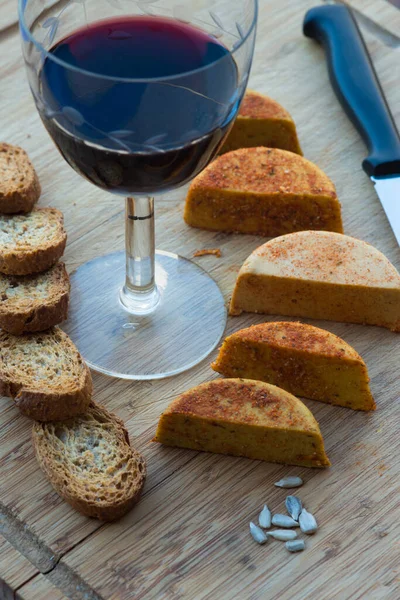 木製のテーブルの上にビーガンチーズ トーストしたパンと赤ワインを伴う — ストック写真