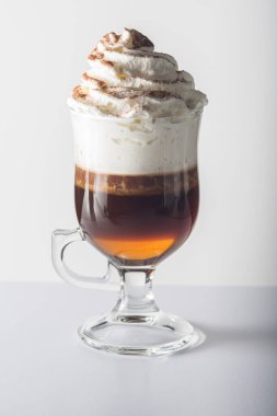 İçinde kahve, krema ve çikolata tozu olan cam bardak..