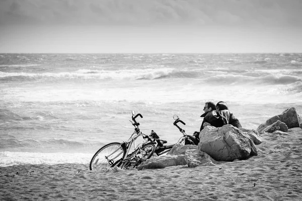 2022年4月11日 一对夫妇骑自行车坐在沙滩上 躲避海滩上的大风 — 图库照片