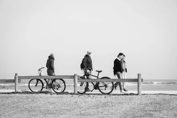 新概念英语900句之基础篇2022年4月13日 几个人在沿着Barcare海滩的小径上 在几辆停放的自行车旁边散步 — 图库照片