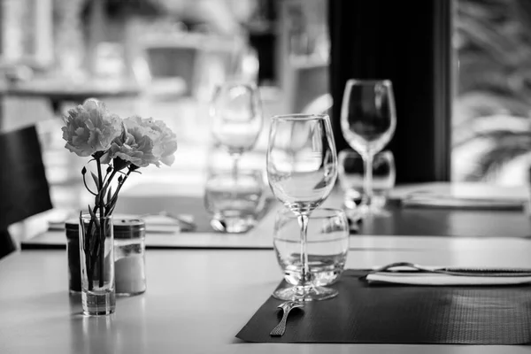 Black White Photograph Restaurant Table Cutlery Glassware Placemats Vase Carnations — Stock Photo, Image
