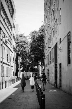 BARCELONA, SPAIN - 7 Haziran 2022: Siyah-beyaz fotoğraf, sırtlarında enstrüman çantalarıyla şehrin sokaklarından birinde yürüyen bazı çocukları görebilirsiniz..