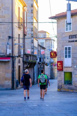 PONTEVEDRA, İSPAN - 7 Temmuz 2022: Bazı hacılar şehrin tarihi merkezinin caddelerinden birinde yürüyorlar.