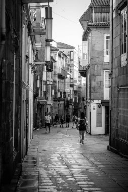 PONTEVEDRA, İSPA - 7 Temmuz 2022: Seyyahlar Camino de Santiago 'ya ait şehir sokaklarından birinde yürürler.