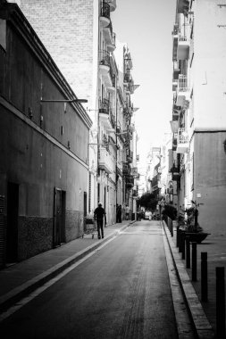 BARCELONA, İSPAIN - 22 Temmuz 2022: Bir adam bir süpermarket tramvayı itti ve satmak için terk edilmiş eşyalar aradı.