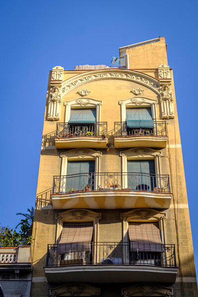 BARCELONA, SPAIN - JULY 22, 2022: Detail of the facade of a buildings, with modernist ornaments, existing in Travessera de Gracia street.