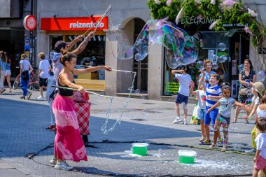 PONTEVEDRA, SPAIN - 6 Ağustos 2022: Birkaç sokak göstericisi, dev sabun baloncuklarıyla oynayarak seyircileri eğlendiriyor.