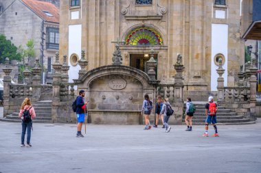 PONTEVEDRA, SPAIN - 7 Ağustos 2022: Bazı hacılar Camino de Santiago yolu olan şehrin sokaklarından birinden yürür.