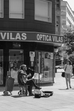 PONTEVEDRA, SPAIN - 7 AĞUSTOS 2022: Şehrin yaya sokaklarından birinde gitar çalan genç bir adam.