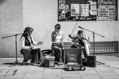 PONTEVEDRA, SPAIN - 10 Ağustos 2022: Bir halk müziği üçlüsü şehrin yaya sokaklarından birinde doğaçlama bir performans sergiliyor.