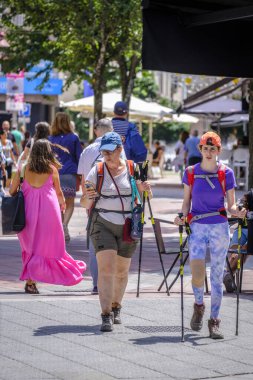 PONTEVEDRA, SPAIN - 10 Ağustos 2022: Camino de Santiago 'yu gezen hacılar, şehrin yaya caddelerinden birinde yürürler..