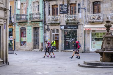 PONTEVEDRA, SPAIN - 11 Ağustos 2022: Camino de Santiago 'yu gezen hacılar, şehrin yaya caddelerinden birinden geçtiler..