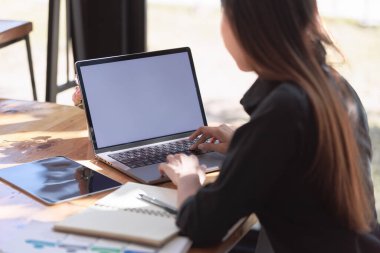 Smartphone ve Laptop 'la çalışma alanında çalışan güzel bir genç kadın.