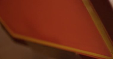 Ekran yazıcısı, tişörtleri mürekkep ve cam sileceği kullanarak bir tişört baskı makinesinde basıyor..