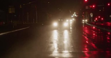 Geceleri yağmurda otoparkta araba..