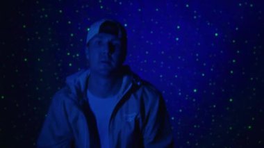 Renkli bir arkaplanda şarkı söyleyen bir rap sanatçısının orta boy fotoğrafı. 4k yüksek çözünürlüklü görüntü. 