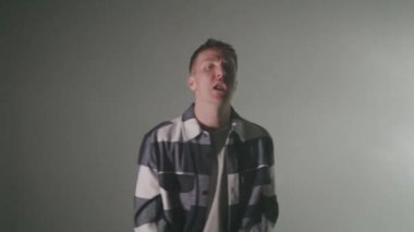 Rap sanatçısının dokulu bir arka planda şarkı söylediği orta boy bir fotoğraf. 4k yüksek çözünürlüklü görüntü. 