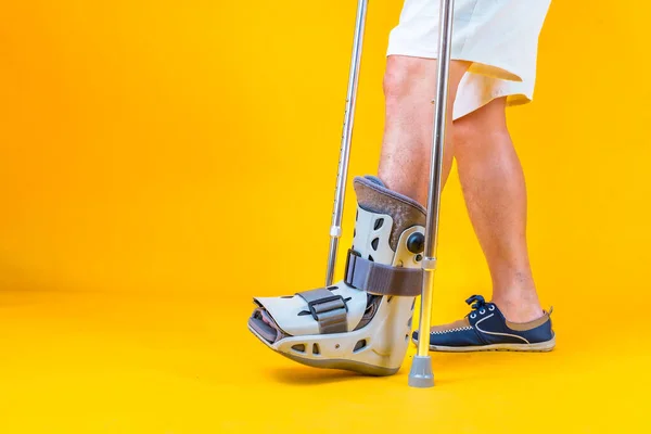 Portrait retired asian senior man walking with crutches in ankle brace , Health problems medical concept.