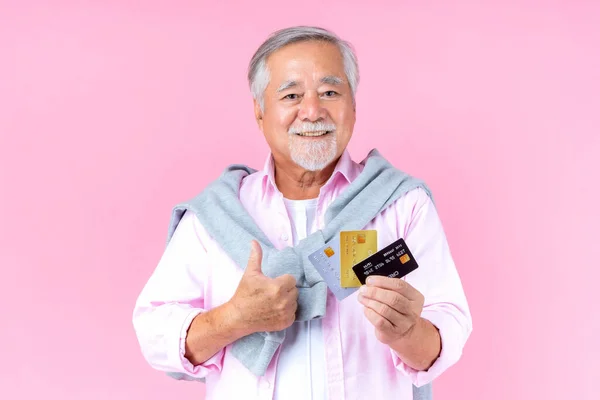 retired asian elderly man with hat broken arm wear arm splint for treatment and smiling and holding credit card for confident lifestyle.