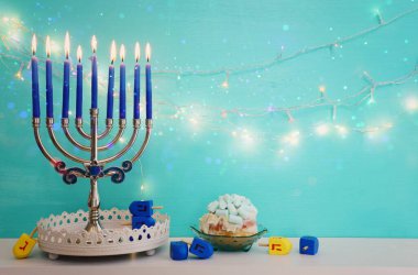 Religion image of jewish holiday Hanukkah background with menorah (traditional candelabra), doughnut and candles clipart