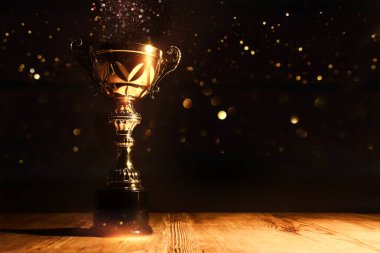 Koyu arkaplan üzerine parlak örtülü altın bir kupa görüntüsü