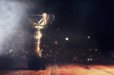 Koyu arkaplan üzerine parlak örtülü altın bir kupa görüntüsü
