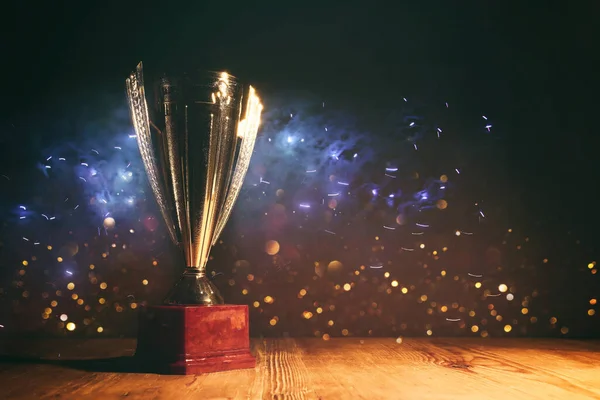 stock image image of gold trophy with sparkly overlay over dark background
